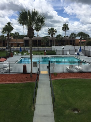Relax by the pool surrounded by lush greenery and comfortable lounge chairs.
