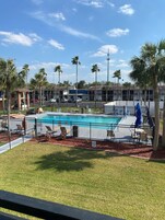 Una piscina al aire libre, sombrillas, sillones reclinables de piscina