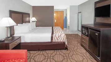 A hotel room with a bed, bedside lamps, a dresser, a TV, and a wardrobe.