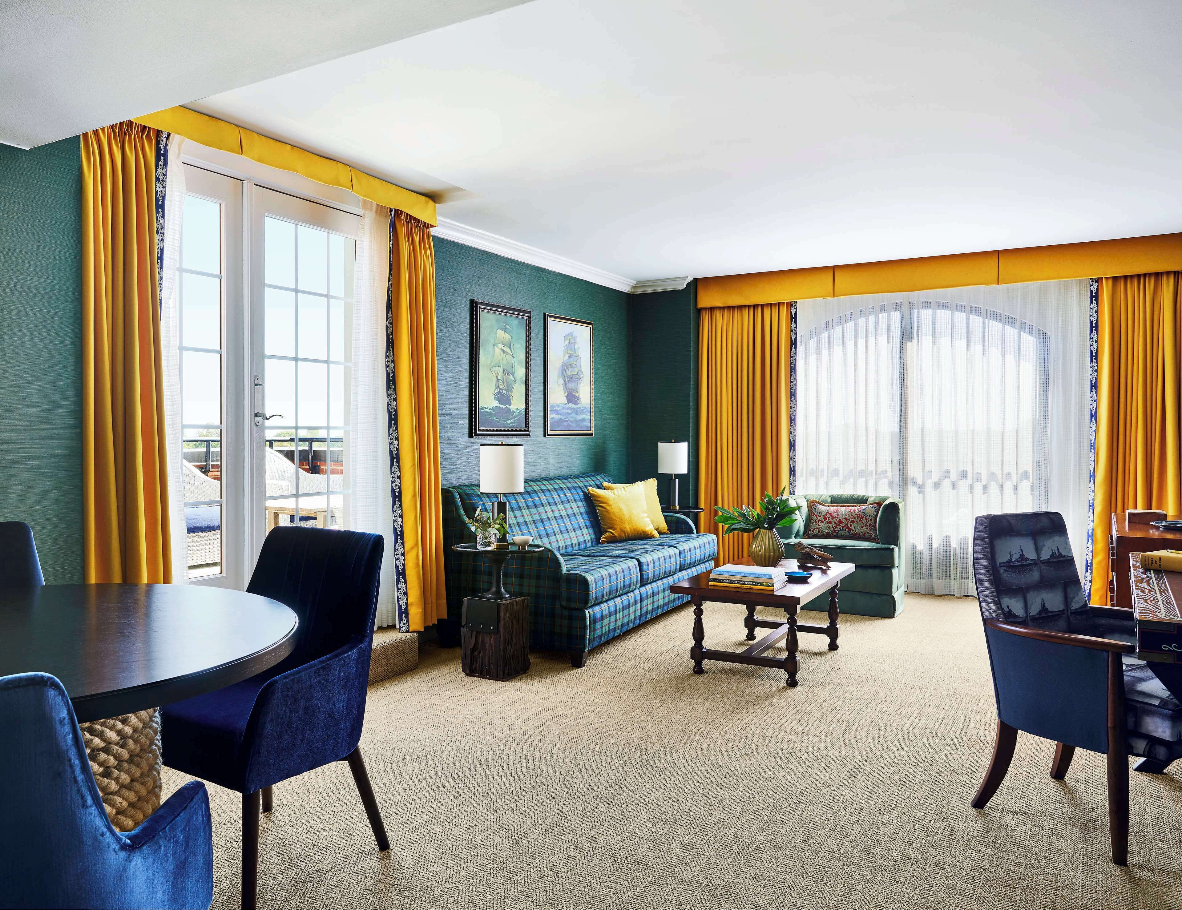Une chambre d’hôtel comprenant un canapé, une table à manger et une chaise.