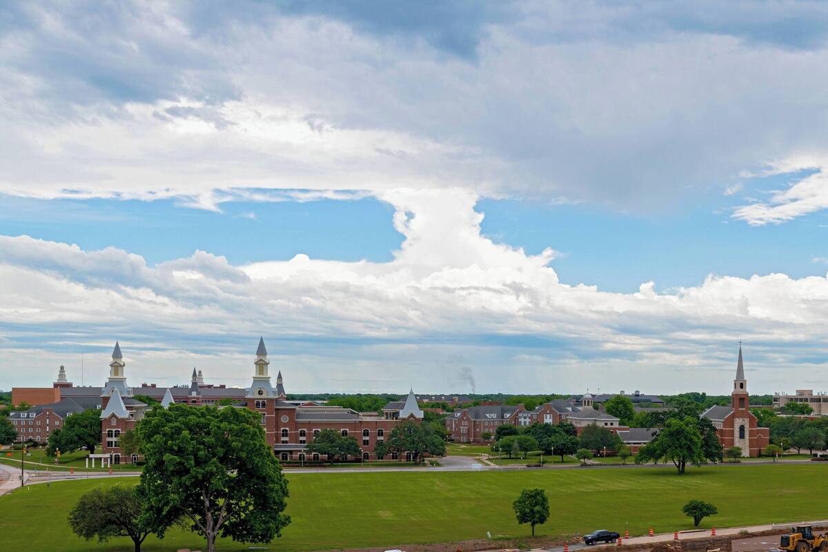 A large, historic building with multiple towers and a prominent church steeple.