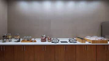 A buffet setup with various food items and condiments.