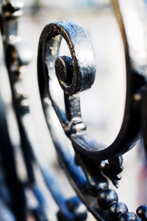 A close-up of a metal railing with a curved design and spherical elements. - Hotel Vaneau Saint Germain (Paris)
