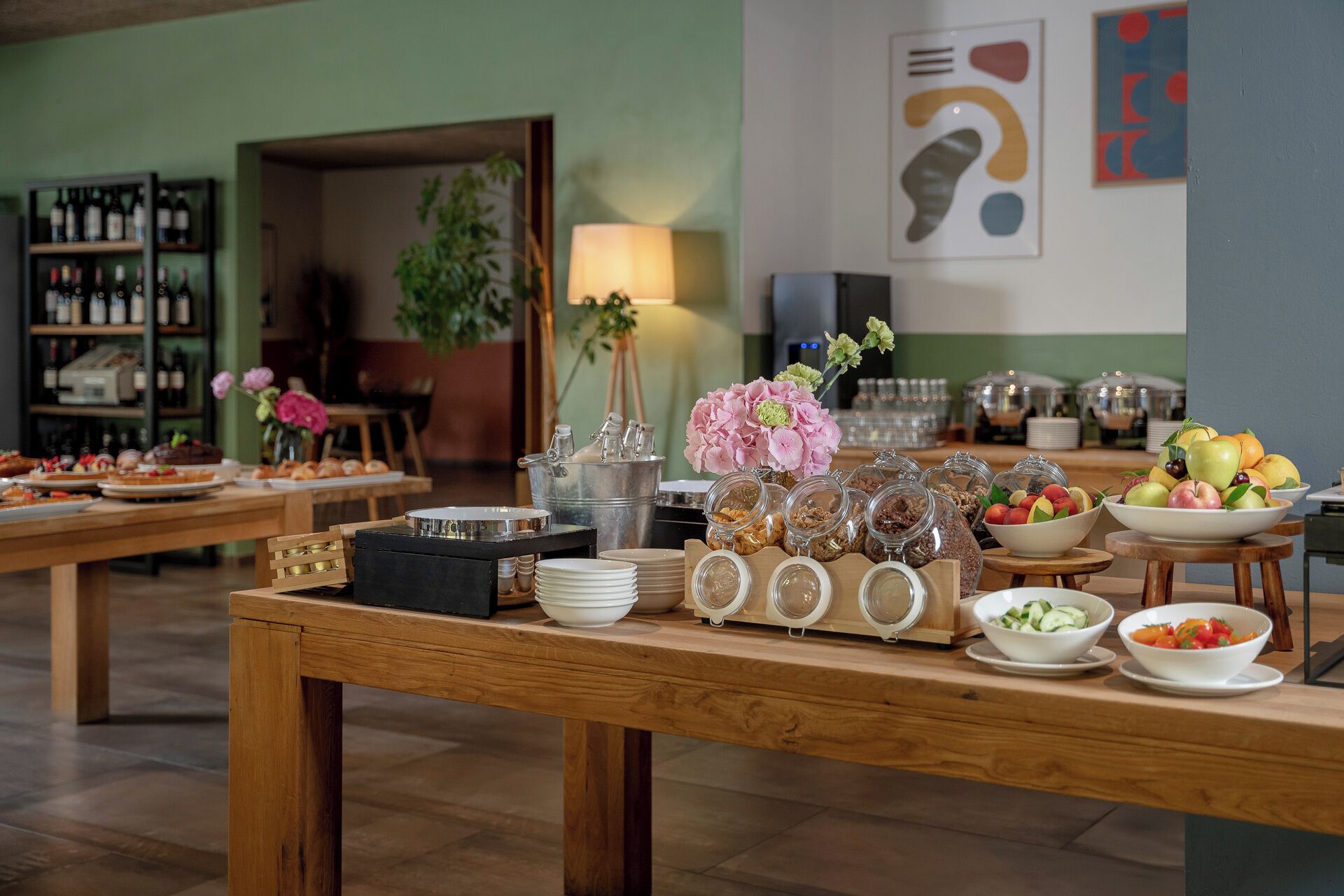 A buffet setup with various food items and a wine selection.