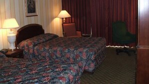 A hotel room with two beds, a desk, a chair, and a lamp. - A Victory Inn & Suites - Ann Arbor (Ann Arbor)