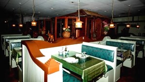 A restaurant with booths and a central dining area. - A Victory Inn & Suites - Ann Arbor (Ann Arbor)
