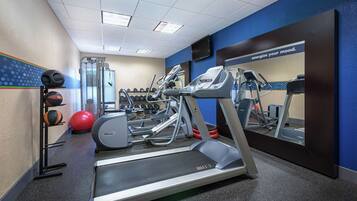A gym with treadmills, elliptical machines, and free weights.