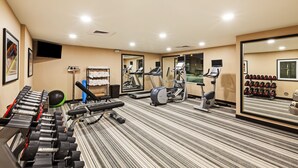 A gym with treadmills, elliptical machines, and free weights.