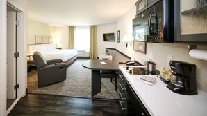 Une chambre d’hôtel équipée d’un lit, d’un bureau, d’une kitchenette et d’un téléviseur.