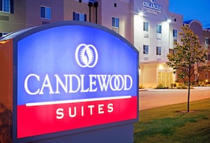 A hotel sign for Candlewood Suites with a clear view of the building in the background.