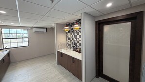 A modern kitchen with a checkered backsplash, a window with a view, and a door with frosted glass.