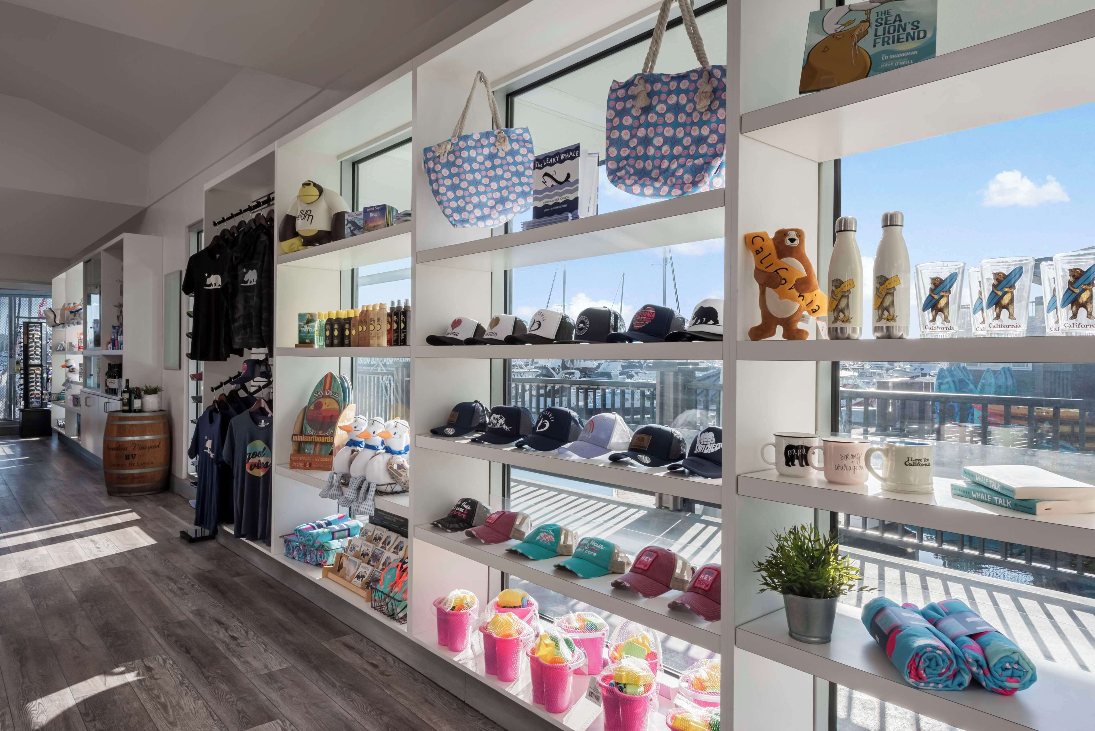 A retail space with shelves displaying hats, mugs, and other merchandise.