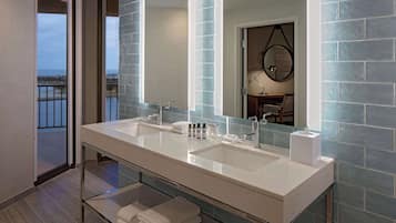 Une salle de bain moderne avec un meuble-lavabo à deux vasques, un grand miroir et une vue sur le balcon.