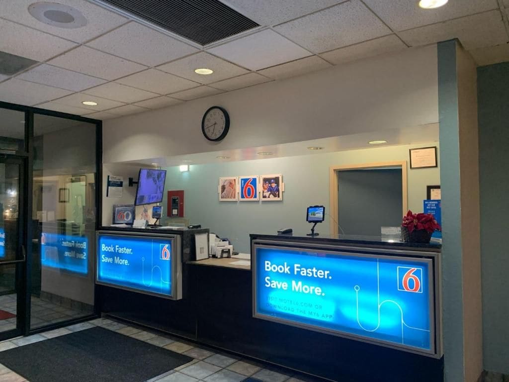 A reception desk with digital displays advertising a book service.
