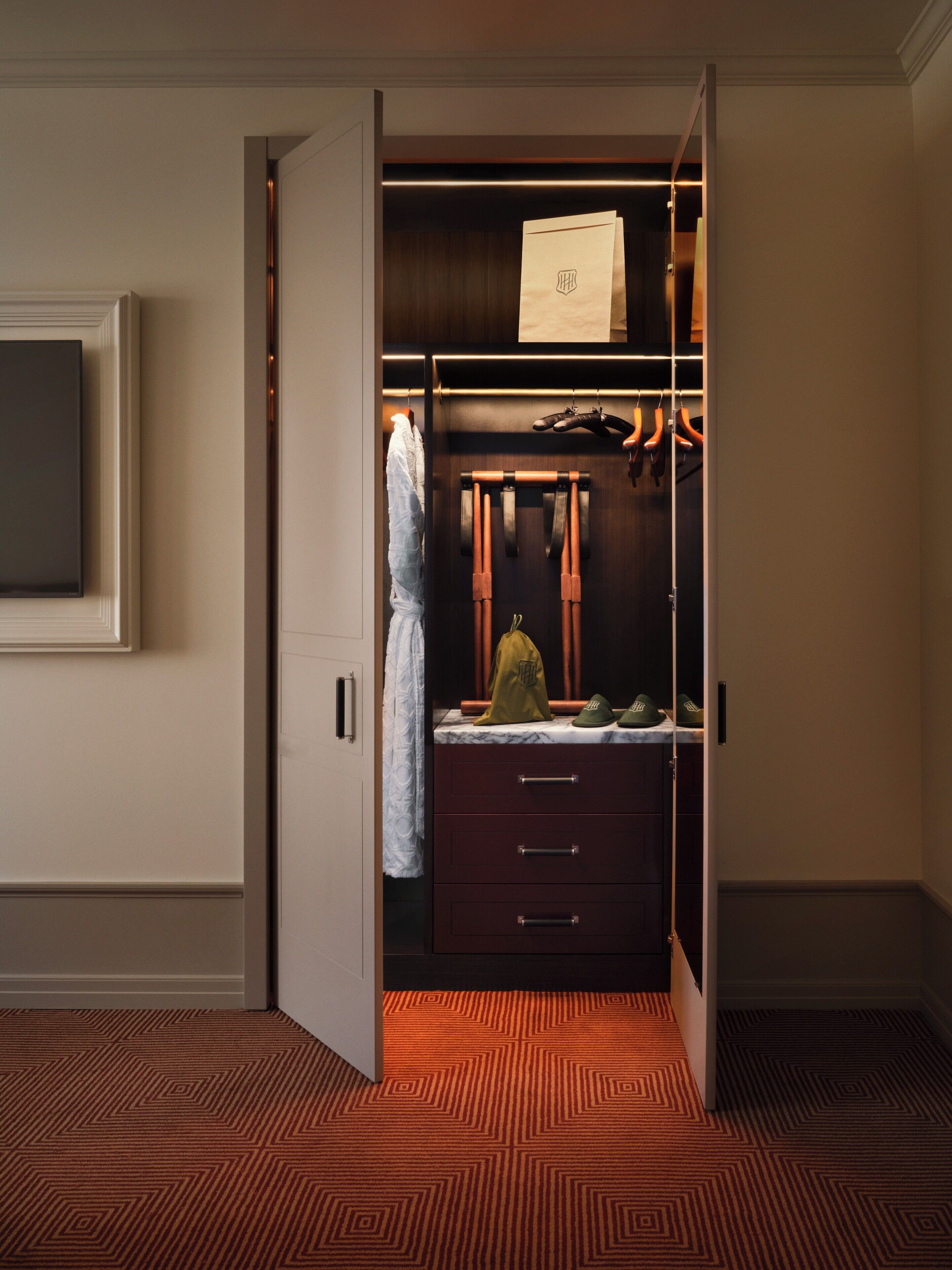 A walk-in closet with hanging space, drawers, and a mirror.