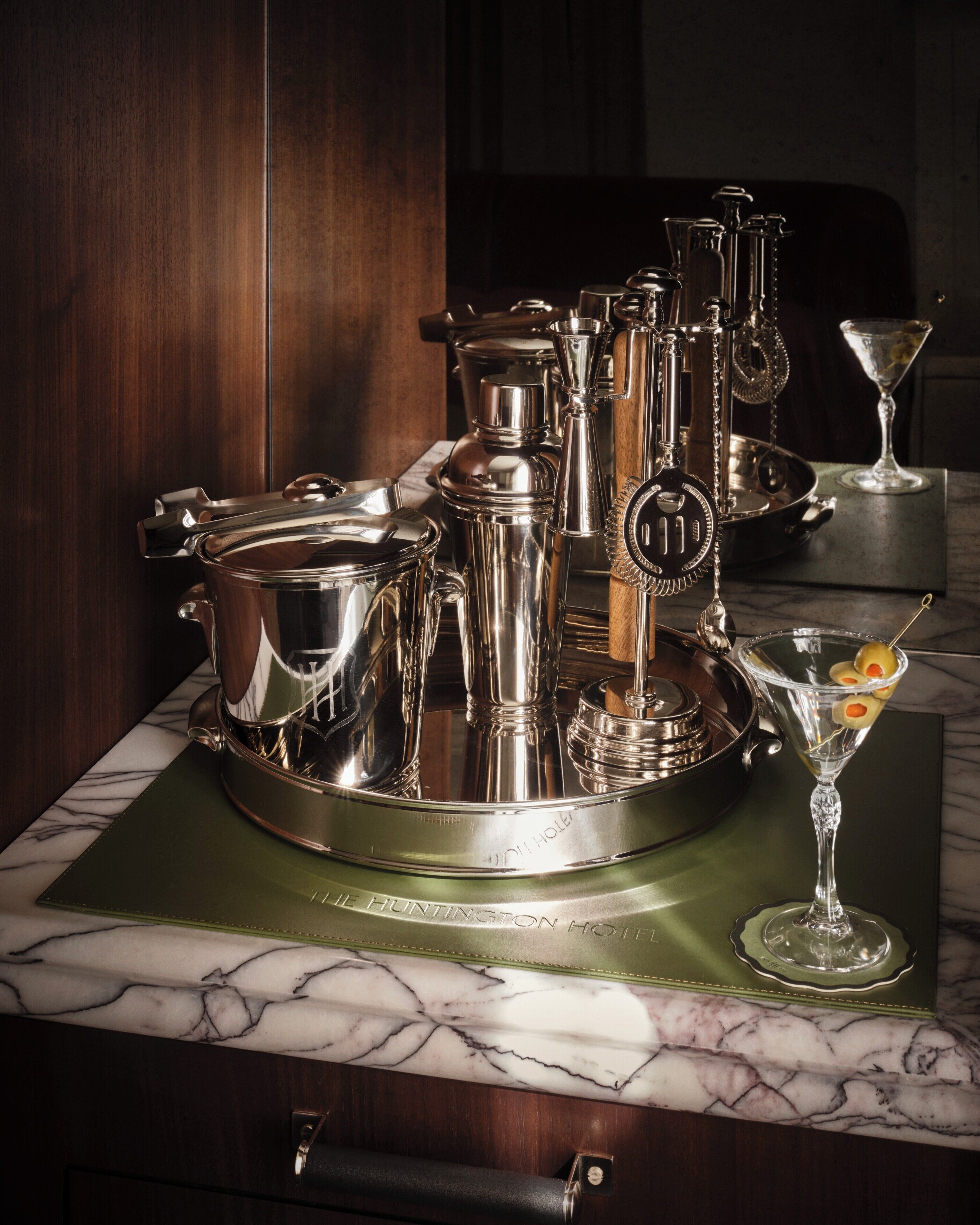 A set of silverware and a martini glass on a marble countertop.