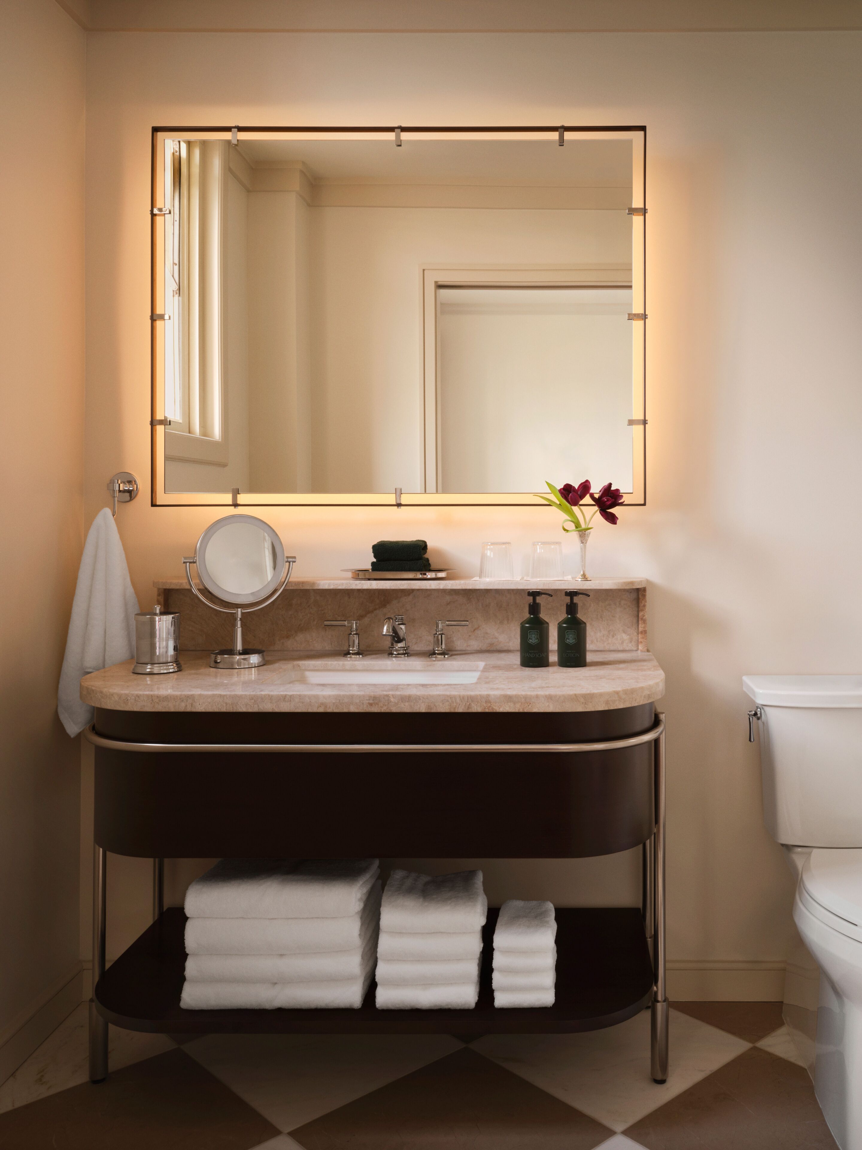 A modern bathroom with a vanity, sink, mirror, and toilet.