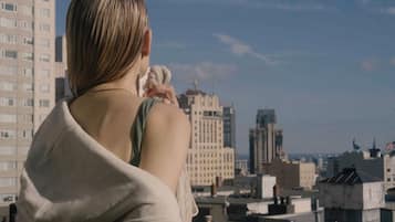 Una persona de pie en una azotea con vistas a un paisaje urbano.