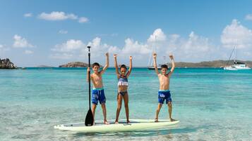 Nyilvános parton, fehér homok, napozóágyak és napernyők