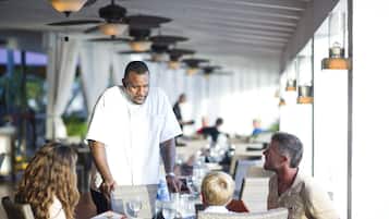 Un restaurant doté d’une terrasse, de ventilateurs de plafond et de lanternes suspendues.
