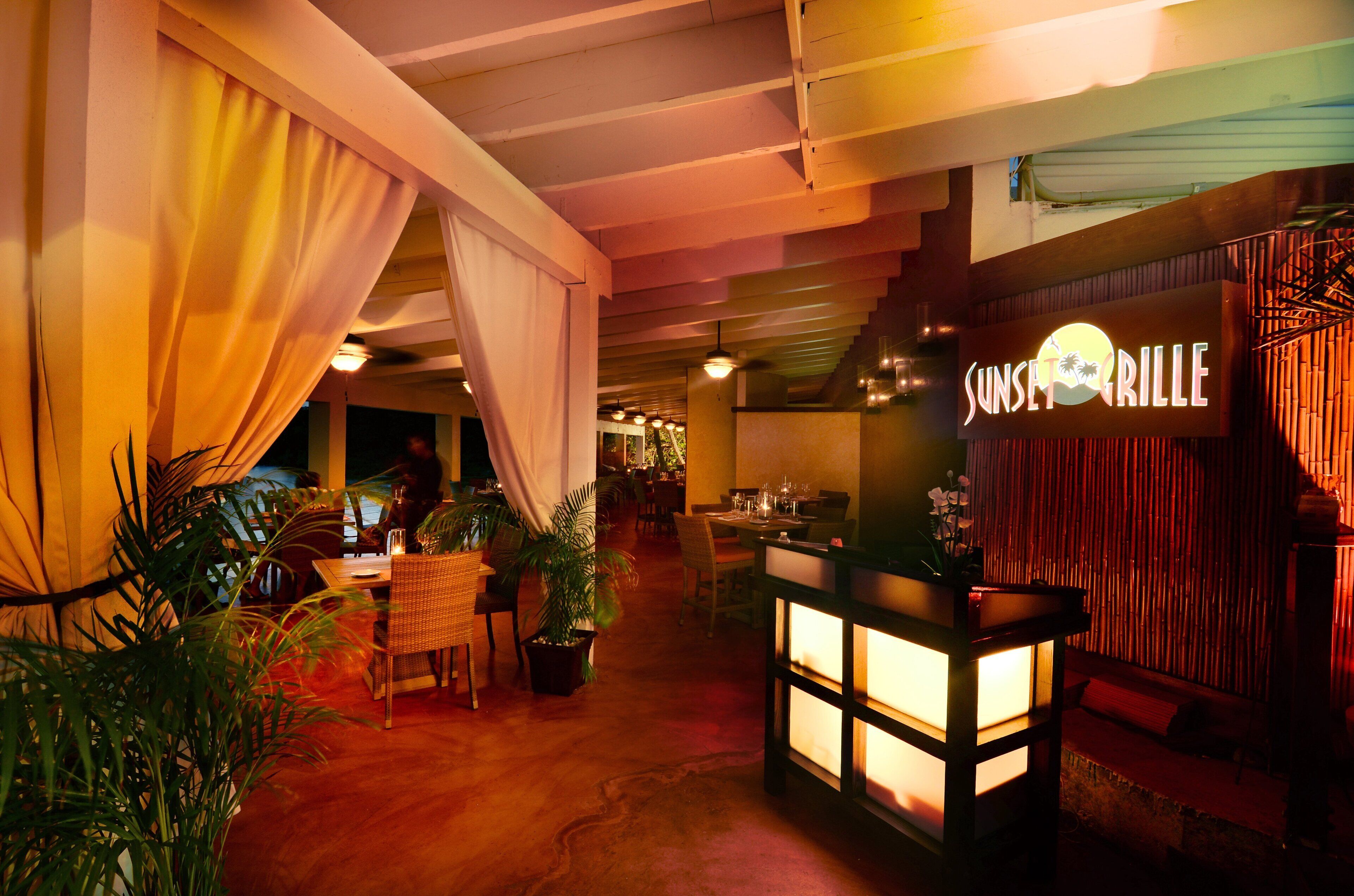 Ristorante interno dall'atmosfera accogliente, con un cartello che riporta la scritta "Sunset Grill".