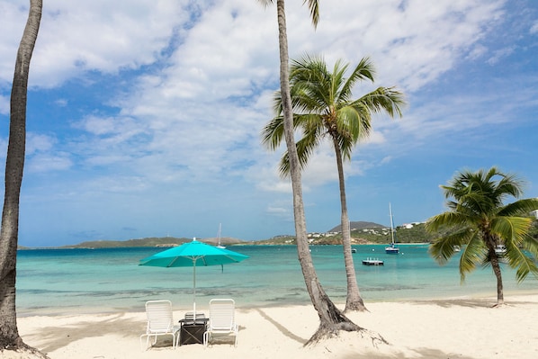 On the beach, white sand, sun loungers, beach umbrellas