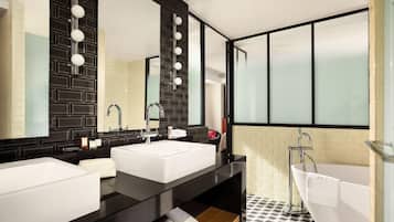 A modern bathroom with two sinks, a large mirror, and a bathtub.