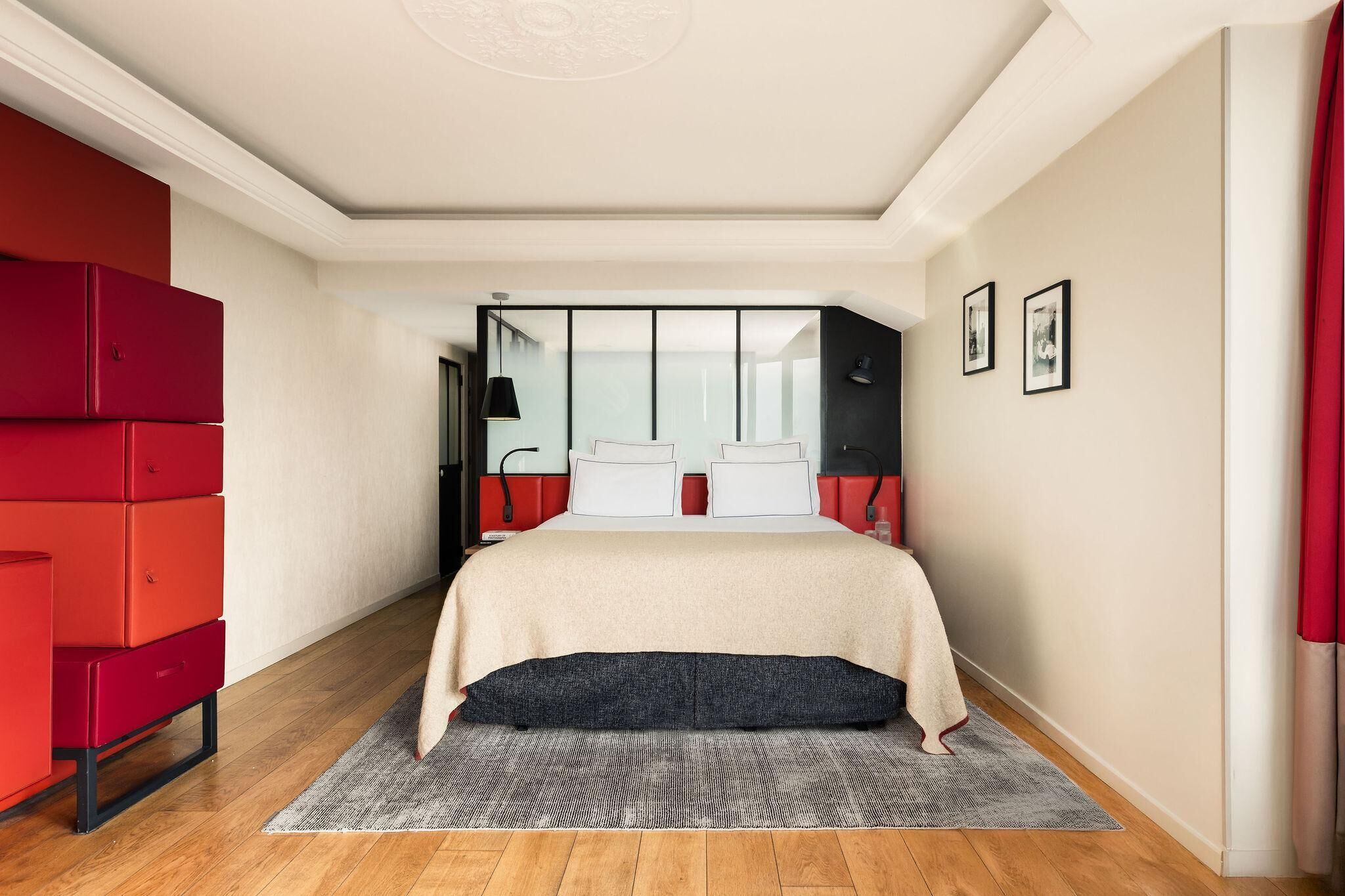 Un dormitorio con una cama, un aparador rojo y un espejo.