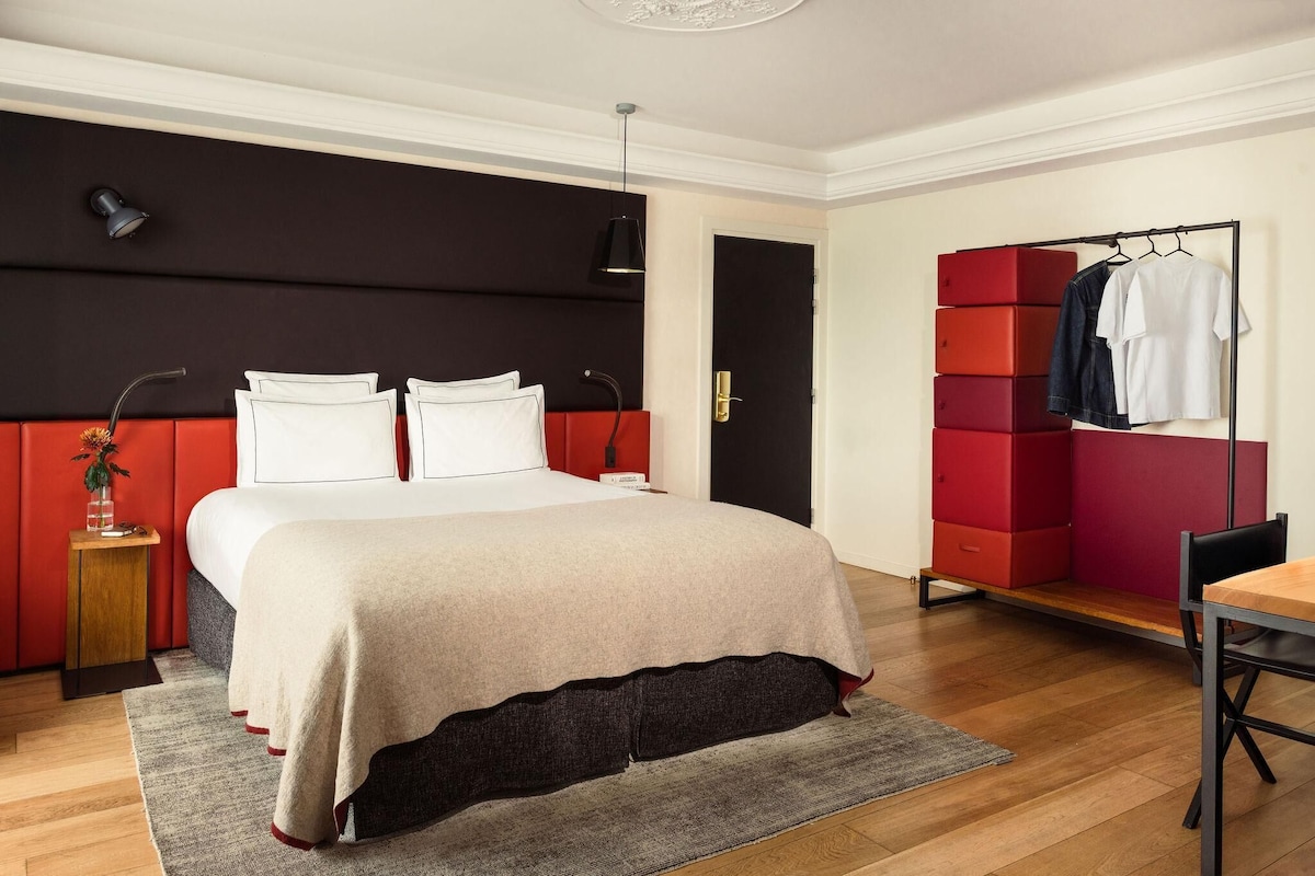 A modern bedroom with a bed, bedside tables, a wardrobe, and a desk.