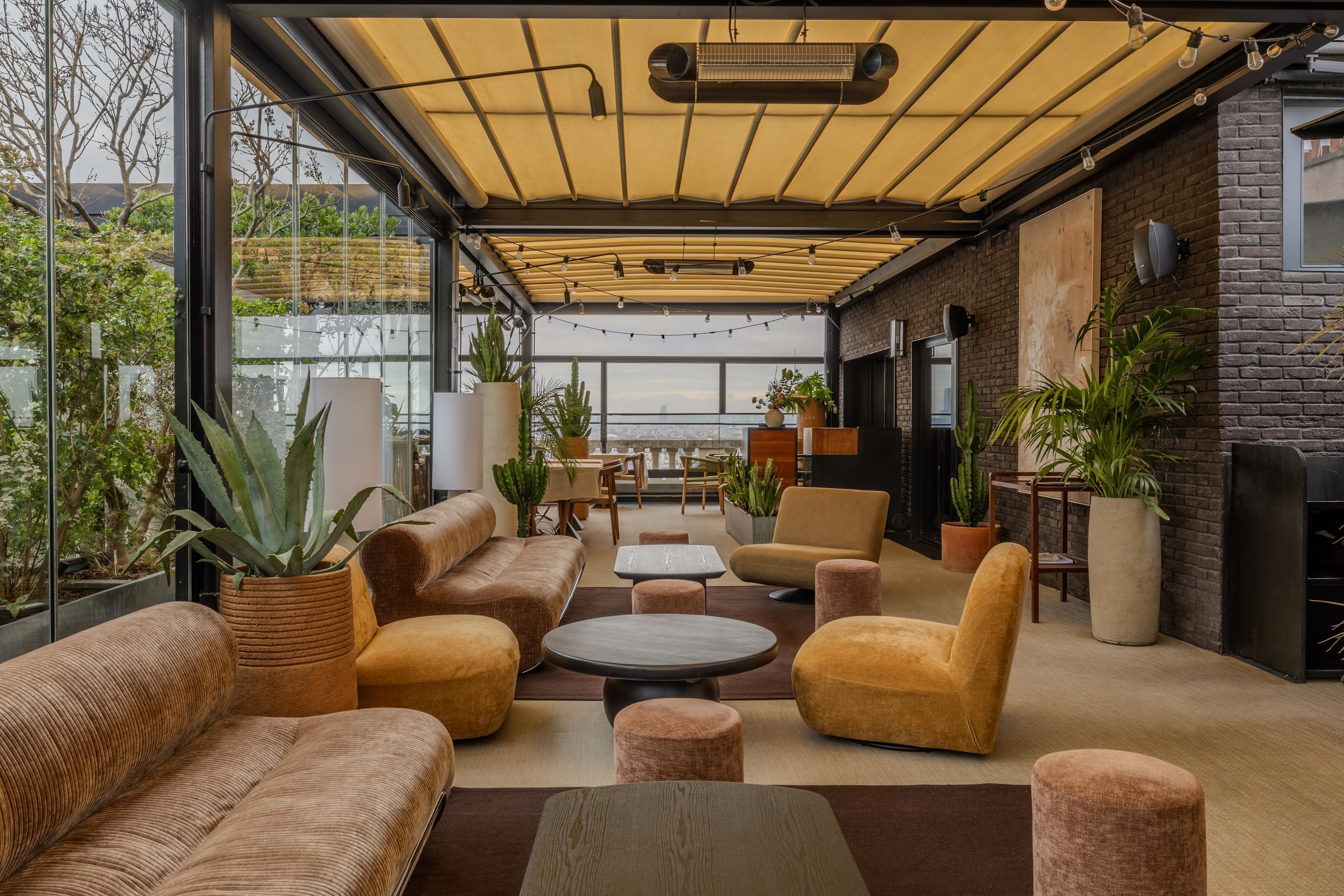 Un espace de détente moderne, avec des canapés, des tables et des plantes en pot.