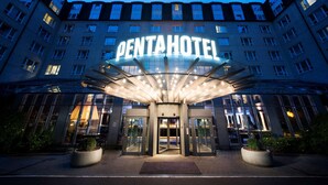 La entrada del Pentahotel, con fachada de vidrio y un letrero llamativo.