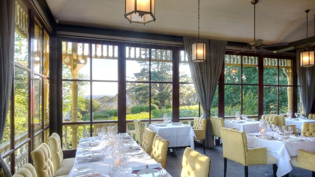 A restaurant with tables set for dining, large windows with a view of greenery, and classic chandeliers. - Ardour Lilianfels Blue Mountains (Katoomba)