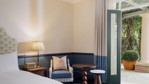 A hotel room with a bed, a chair, a table, a lamp, and a view of greenery outside. - Ardour Lilianfels Blue Mountains (Katoomba)
