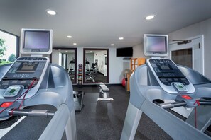 A gym with treadmills, a mirror, and exercise equipment.