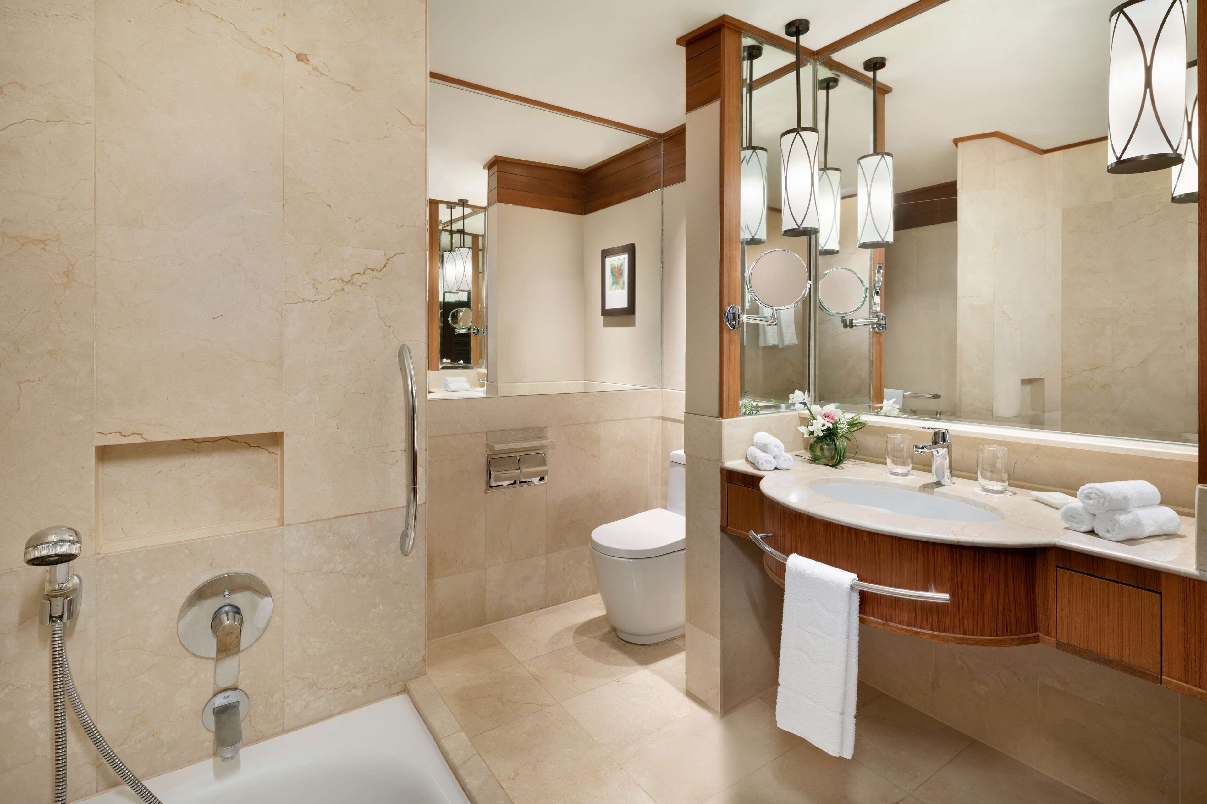 A modern bathroom with a bathtub, shower, and sink.