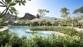 Una piscina rodeada de exuberante vegetación y arquitectura tradicional.