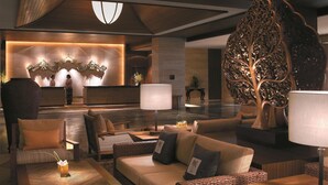 A modern lobby with a reception desk, seating area, and decorative elements like a large leaf sculpture and wall art. - Shangri-La Rasa Sayang, Penang (George Town)