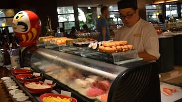 A buffet with various food items and a chef preparing food.