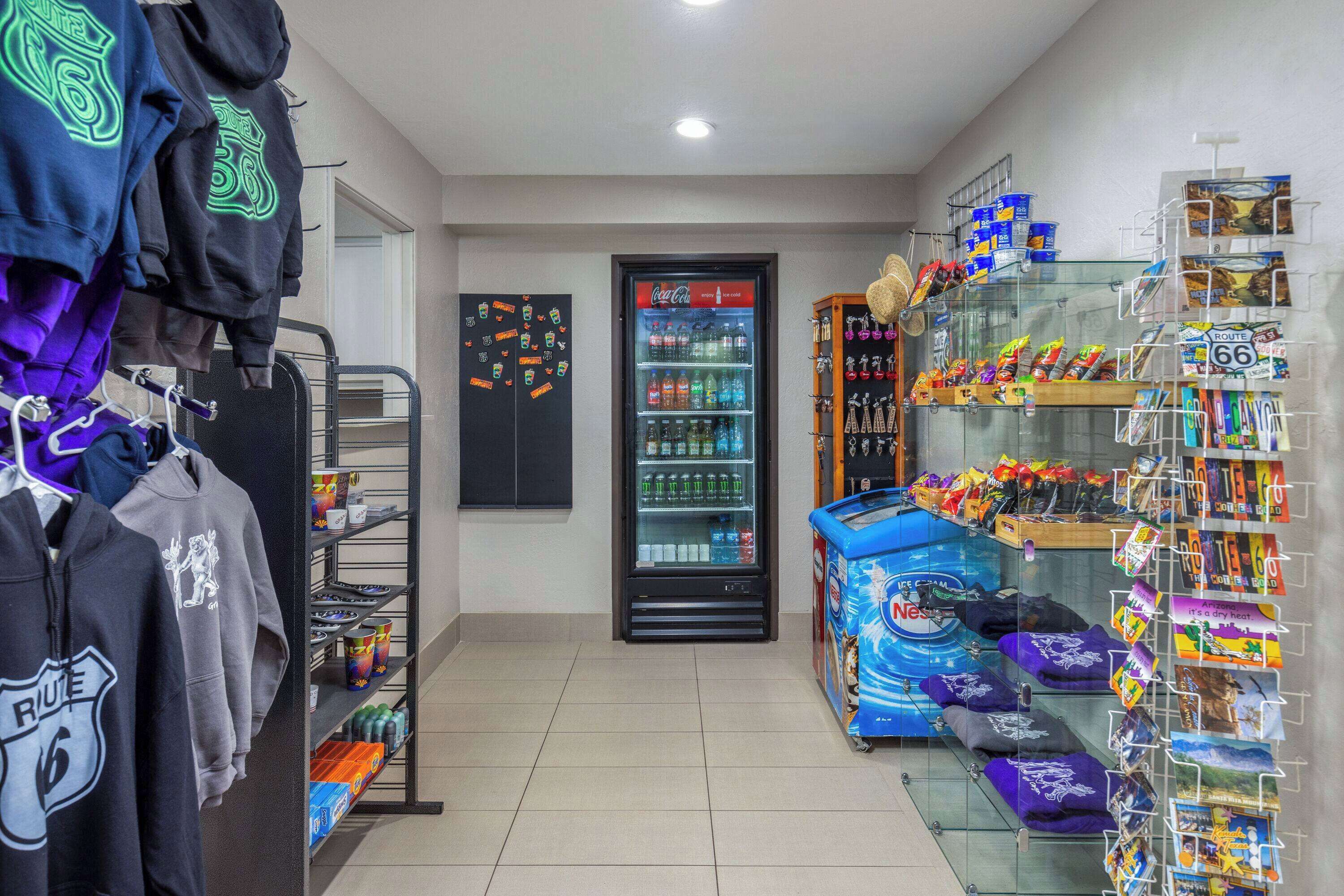A retail area with a vending machine, shelves stocked with snacks, and a display of branded merchandise.