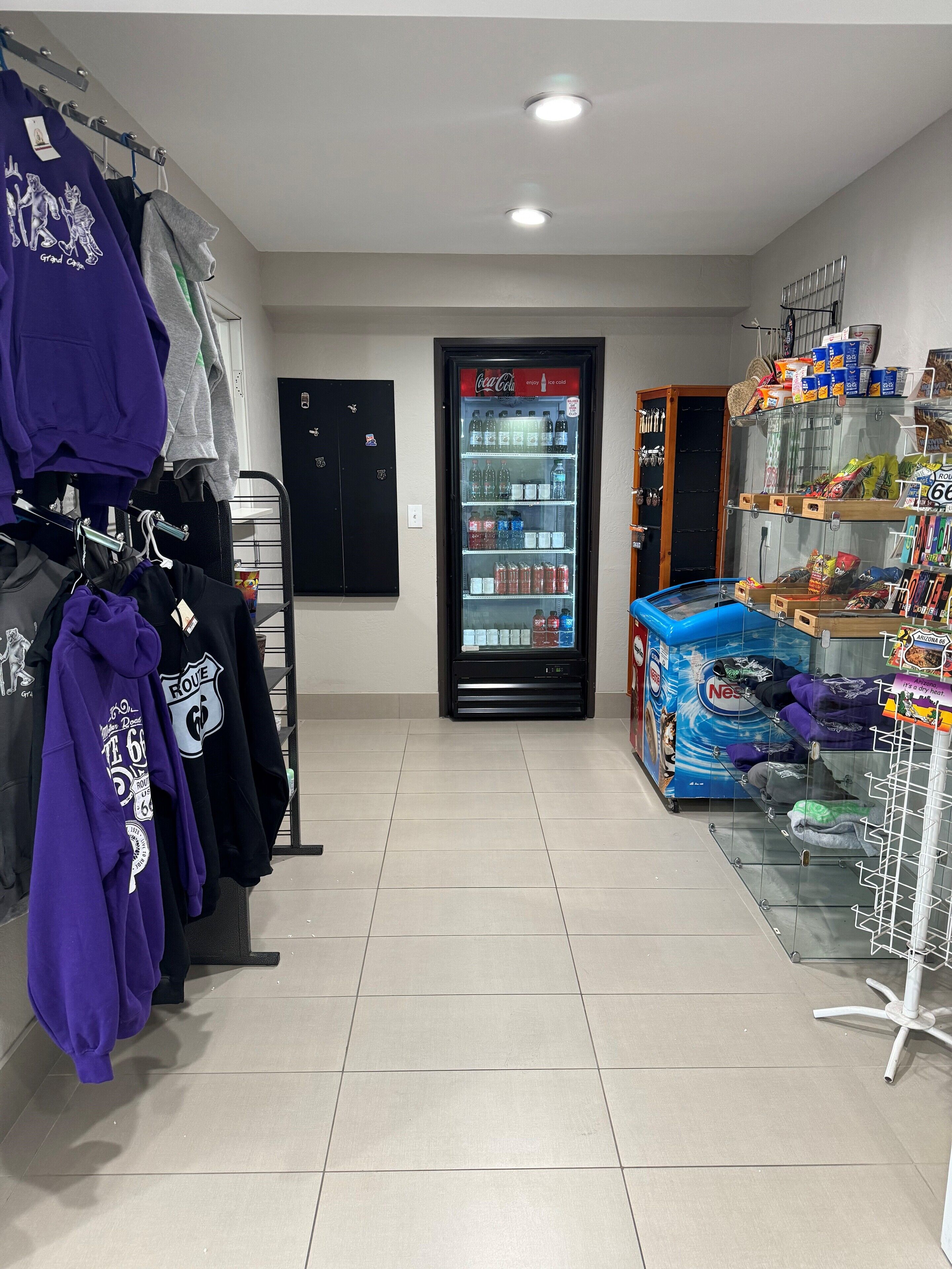 Una habitació amb màquina expenedora, prestatges de roba i presentació de llaminatures.