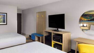 Habitació d'hotel amb dos llits, televisió, escriptori i una cadira.