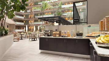 Experience the sleek, open-plan lobby with a spacious reception desk, comfortable seating, and lush greenery.