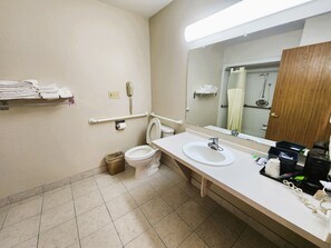 Casa de banho com sanita, lavatório, espelho e porta-toalhas.