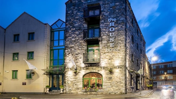 A stone building with a sign reading "the HOUSE hotel".