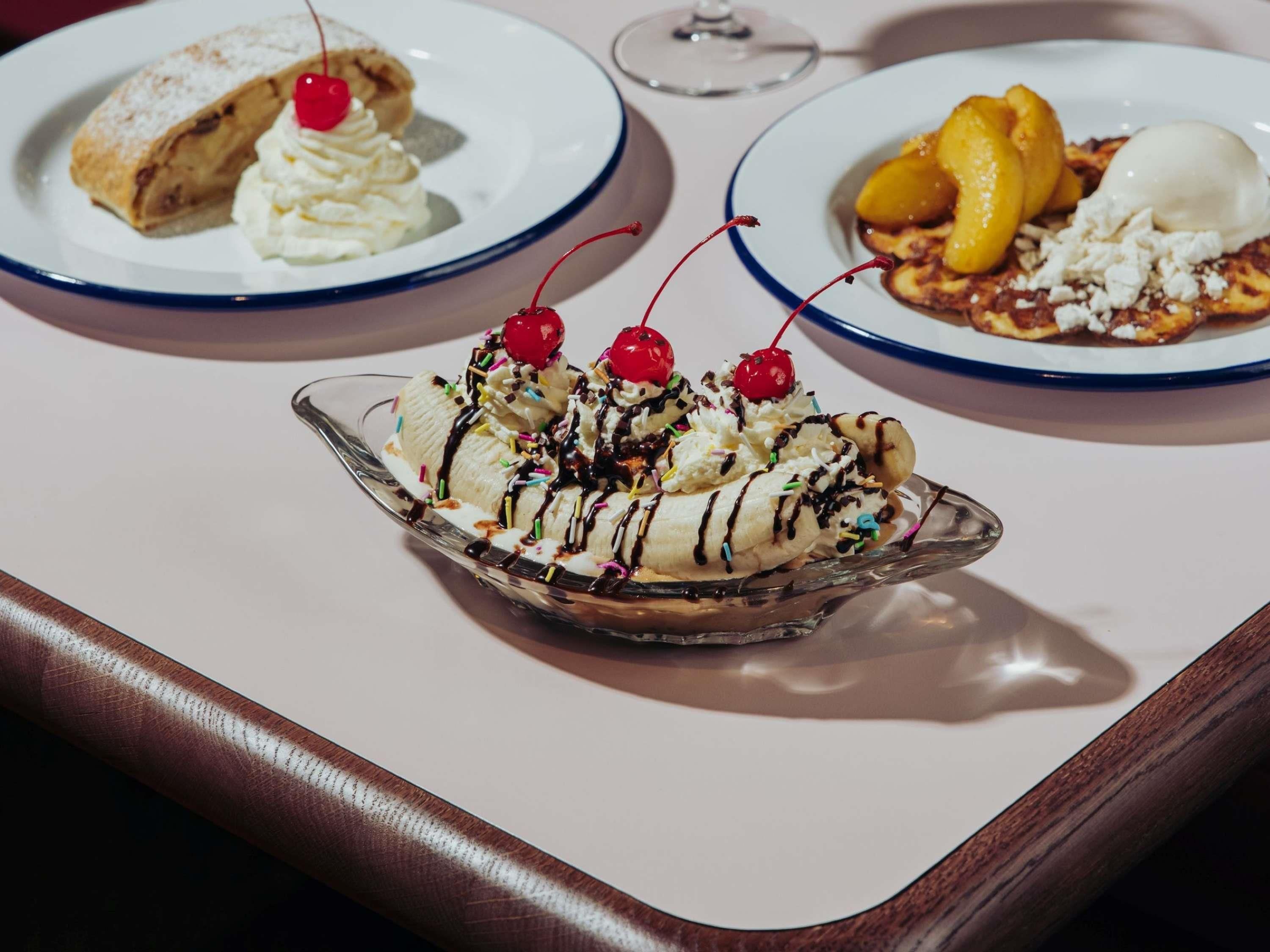 A dessert tray with banana split, apple pie, and peach dessert.