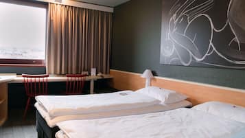 Habitación de hotel con dos camas, un escritorio, una silla, una lámpara y un cuadro abstracto grande en la pared.