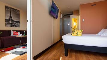 Ein Hotelzimmer mit Bett, einer Couch, einem Couchtisch und einem Stadtbild.