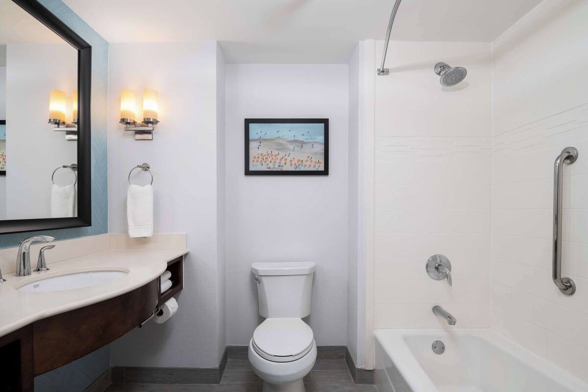 Un baño moderno con lavamanos, inodoro y bañera.