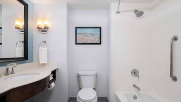 A modern bathroom with a sink, toilet, and bathtub.