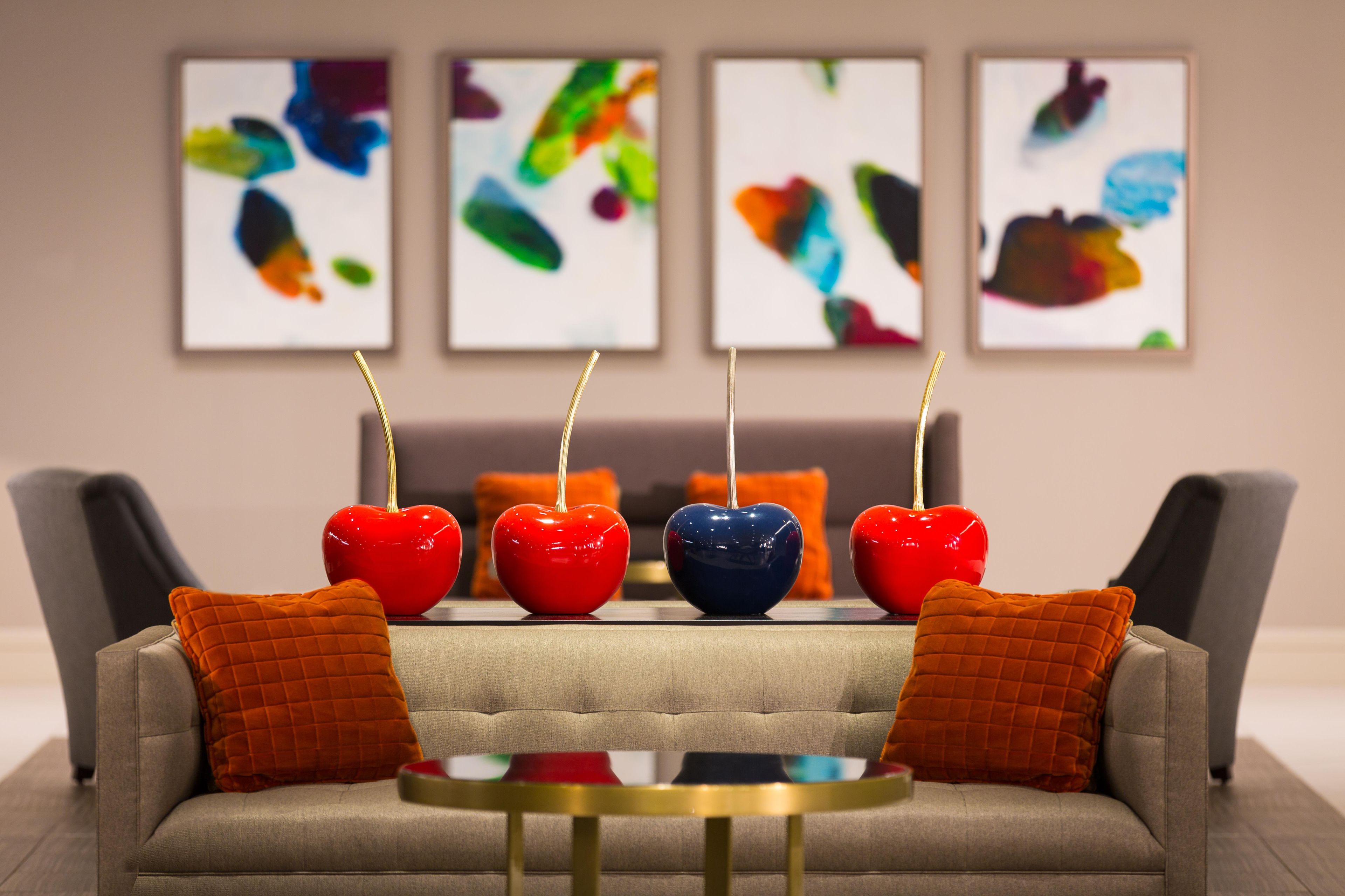 Ein modernes Wohnzimmer mit einer Couch, einem Couchtisch und vier Äpfeln auf Spießen.